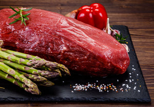 Raw chateau briand displayed with asparagus, red bell pepper, sea salt and rosemary leaves. King George's Steak and Seafood. 