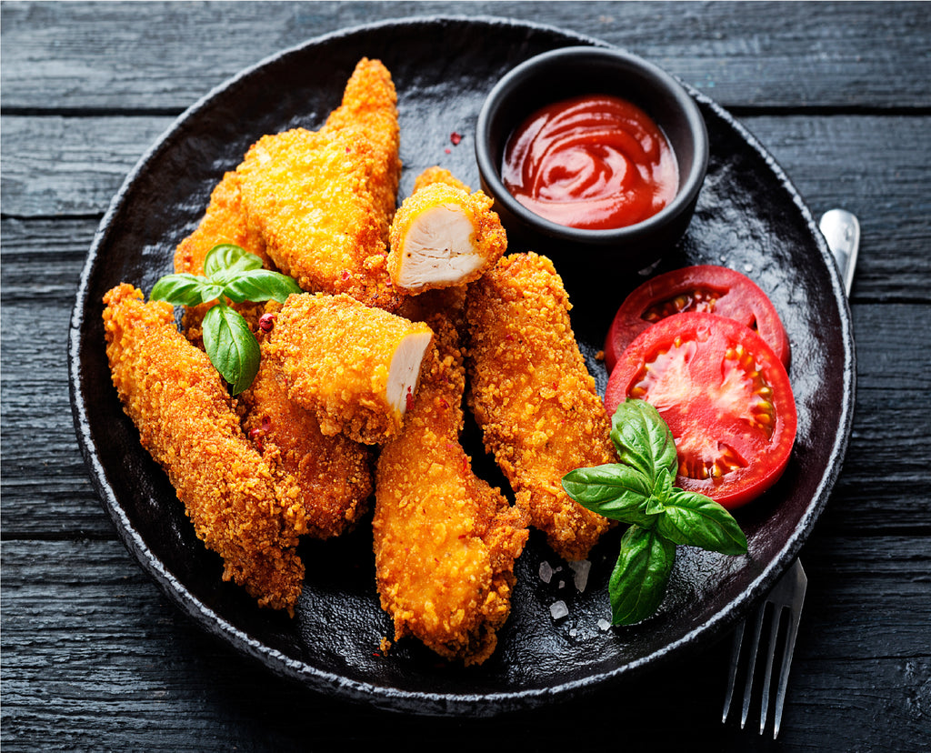 Chicken fingers baked and served with tomato slices, mint leaves, and ketchup on the side. King George's Steak and Seafood. 