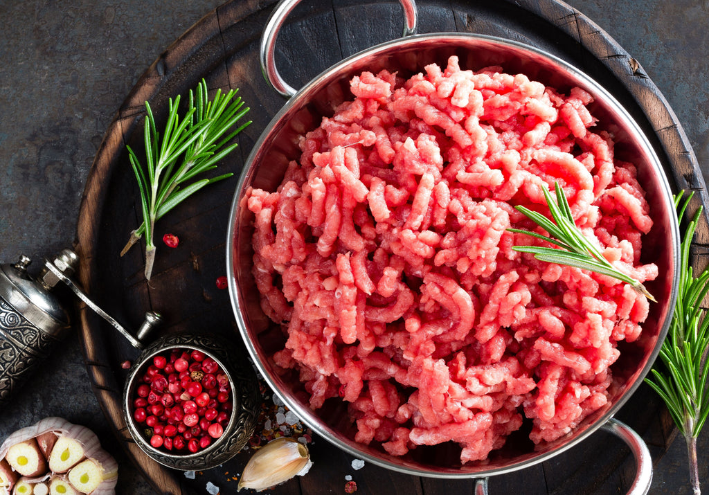 Raw Ground Veal displayed with peppercorn, rosemary and garlic. King George's Steak and Seafood. 