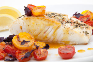 Halibut fillet baked and served with cherry tomatoes, spices and sauce. King George's Steak and Seafood.