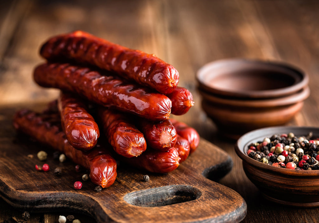 Italian sausages grilled and displayed on a cutting board and peppercorns. King George's Steak and Seafood.