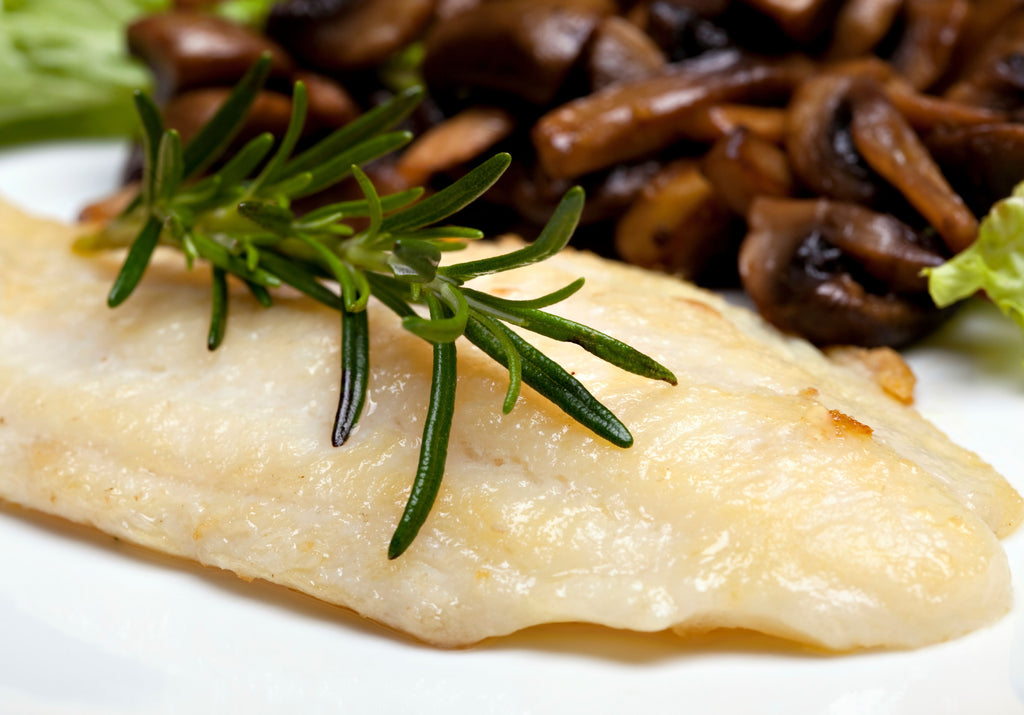 Baked Sole Fillet served with cooked mushrooms and garnished with rosemary. King George's Steaks and Seafood.