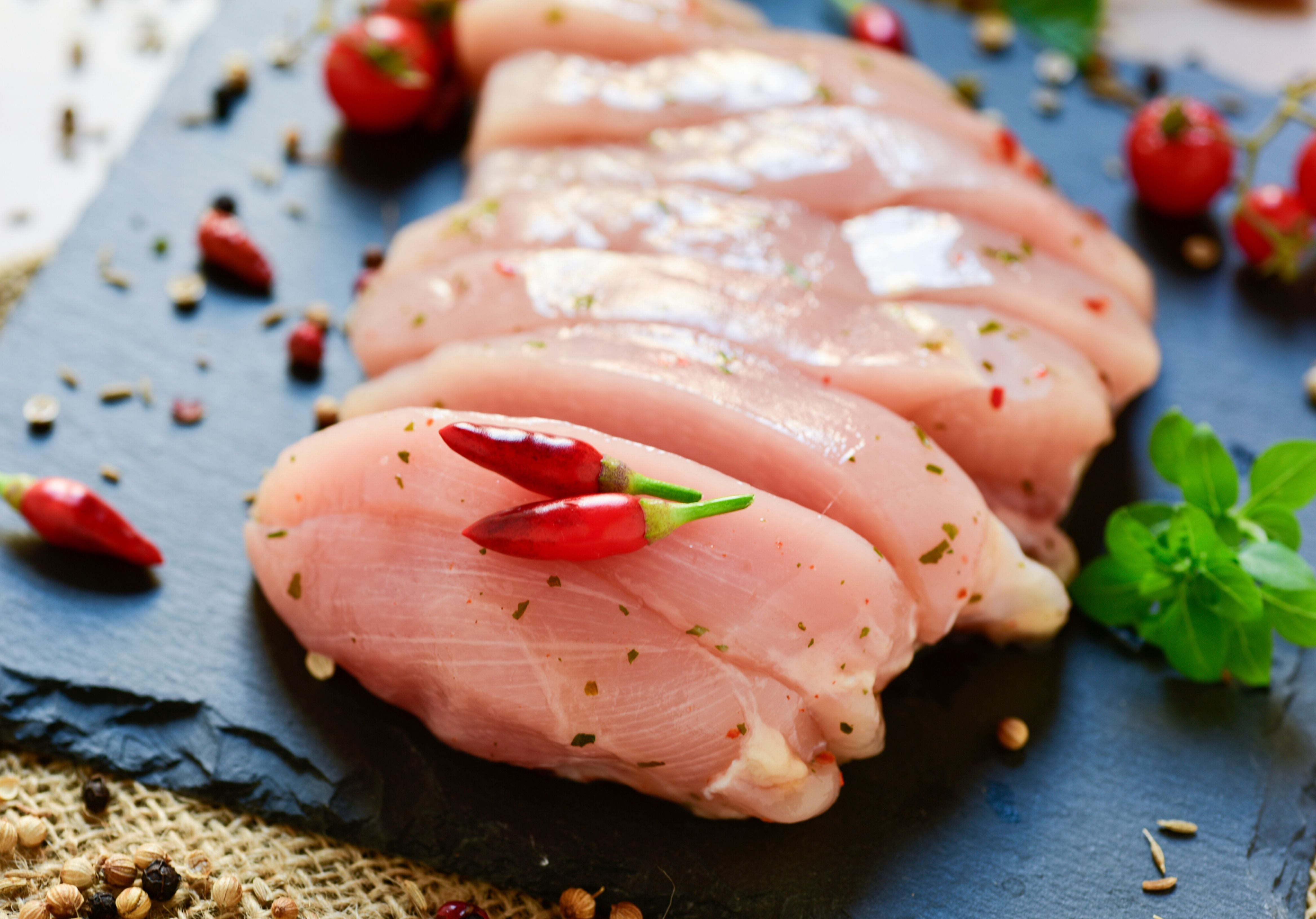 Raw Turkey Breasts garnished with spices, red chilies, and tomatoes. King George's Steak and Seafood.